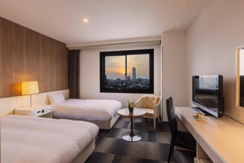 泉佐野王子空港城市酒店的酒店客房设有两张床和电视。