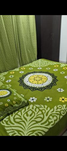达卡4Couples的一张带绿毯的床,上面有鲜花