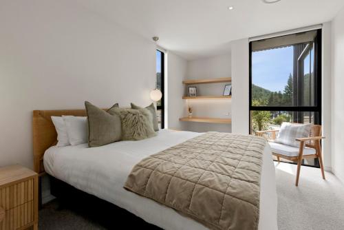 特卡波湖Station Bay Lodges - The Retreat的卧室配有床、椅子和窗户。