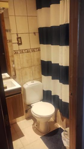 蓬塔阿雷纳斯casa sergio的浴室设有卫生间和黑白淋浴帘。