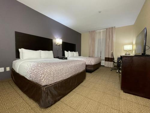 休斯顿Spark Suites Hobby Airport的酒店客房设有两张床和电视。