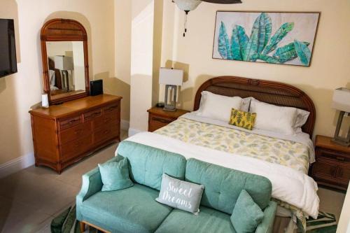 自由港市Canal Front Comfort (Dock slip available)的一间卧室配有一张床、一张沙发和一面镜子