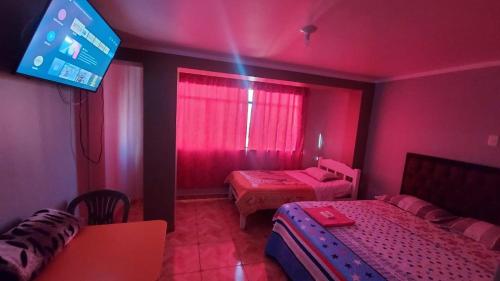 阿亚库乔SOL DEL NORTE的粉红色的客房设有两张床和电视。