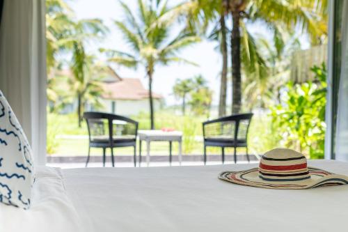 谭奎TUI BLUE Nam Hoi An Resort的桌子上的帽子,享有庭院的景色