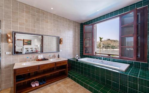琅勃拉邦Relaxful Hotel泊岸酒店的一间带两个盥洗盆、浴缸和窗户的浴室