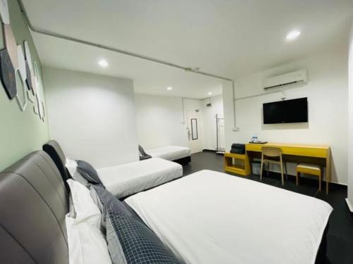 Wakaf BaharuHalo Rooms Hotel的客房设有两张床、一张桌子和电视。