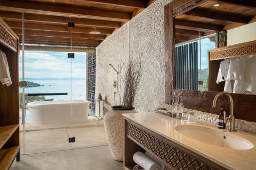 圣吉吉Kalandara Resort Lombok的一间带大浴缸和水槽的浴室