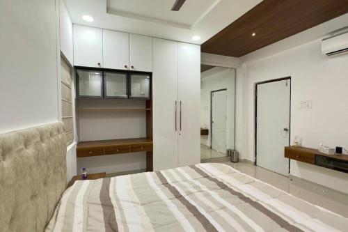 海得拉巴Brand New Luxurious Independent Villa的一间卧室配有一张床,厨房配有橱柜
