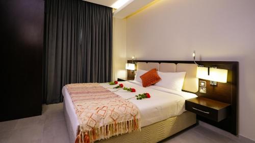 科威特Saray Hotel Apartments的一间卧室配有一张带鲜花的大床