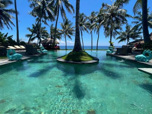 提安亚尔Louka Beach Bali的棕榈树度假村的游泳池