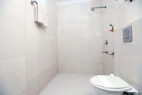 新德里Hotel Mars Meg at Delhi Airport的白色的浴室设有卫生间和淋浴。