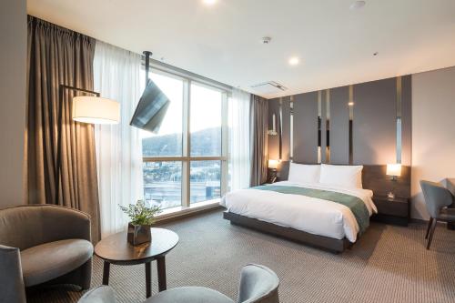 釜山Centum Prime Hotel的酒店客房设有一张床和一个大窗户