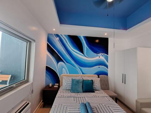 圣费尔南多Hailey's Crib @ Azure North的一间卧室配有一张壁画床