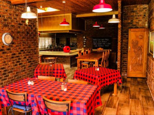 纽卡斯尔Pheasant's Rest Guest House的餐厅设有2张桌子和椅子,配有红色和蓝色的格子桌