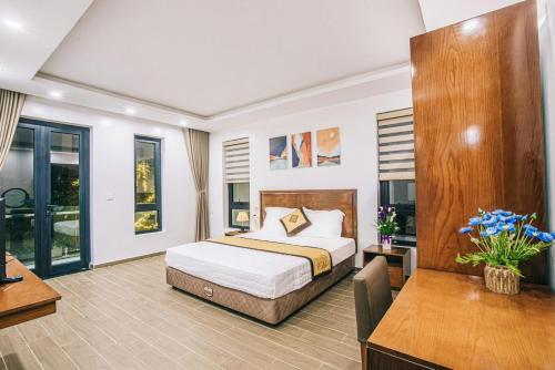 岑山Villa FLC Sầm Sơn KT 03-03的卧室配有一张床、一张书桌和窗户。