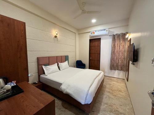 印多尔Kasa Comfort Inn的卧室配有一张白色大床和电视。
