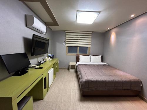 巨济Vision motel的小房间设有床和电视