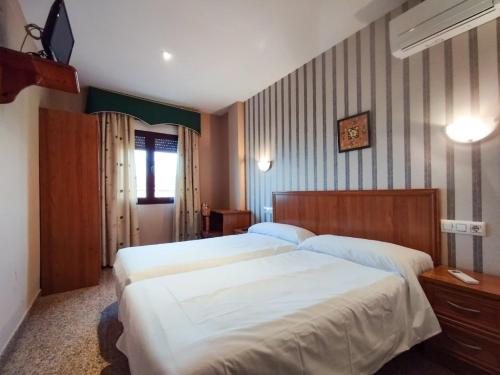 罗德里戈城教堂之门宾馆的一间卧室配有两张大床