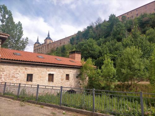 莱尔马Albergue Molino Solacuesta的一座古老的石头建筑,后面是一座城堡