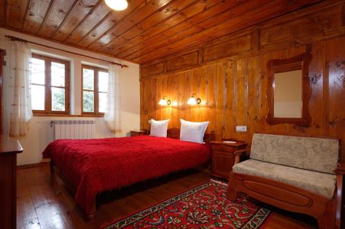 泽拉夫纳Yovina House Zheravna的一间卧室配有红色的床和椅子