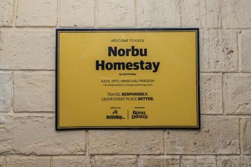加沙NotOnMap- Norbu Homestay Kaza的砖墙上的黄色标志