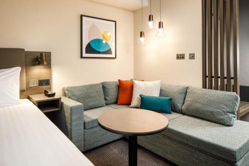 霍尔Holiday Inn Manchester Airport, an IHG Hotel的客厅配有沙发和桌子
