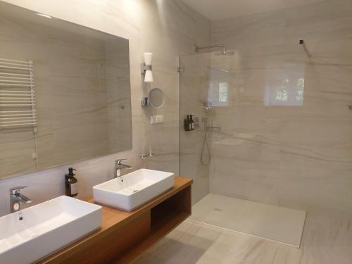 米科瓦伊基力士别墅旅馆的一间带两个水槽和玻璃淋浴间的浴室