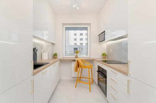 热舒夫Bright Apartment with Spacious Balcony and Air Conditioning by Renters的厨房配有白色橱柜和黄色凳子