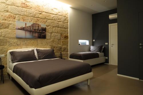 巴里Pane e Pomodoro的一间卧室设有一张床和石墙