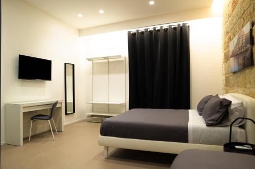 巴里Pane e Pomodoro的一间卧室配有一张床、一张书桌和一台电视