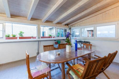 茨雷斯Guesthouse Romana的一间带木桌和椅子的用餐室