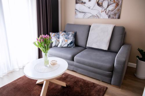 波兹南Apartament Bimba - Free Parking的客厅配有沙发和鲜花桌
