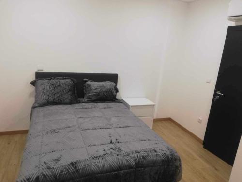 米兰德拉Casa de São Miguel的卧室配有带灰色棉被的床