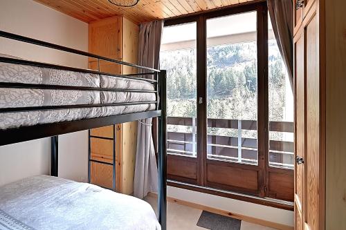 拉布雷斯Le Cocoøn - Appt vue montagne的一间卧室设有一张双层床和大窗户。