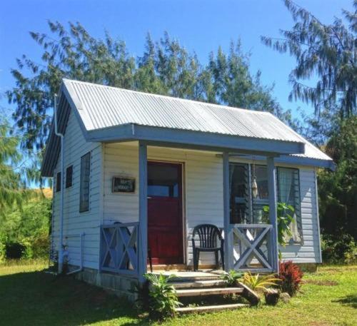 Nanuya LailaiBay of Plenty Nature Lodge的一间白色的小房子,有红色的门