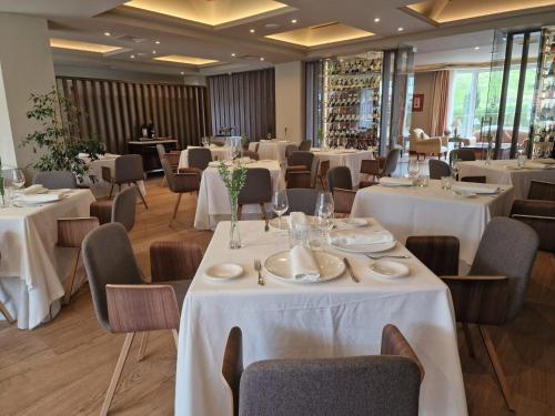 蓬特维耶斯戈普恩特维斯戈水疗大酒店的餐厅配有桌椅和白色的桌布