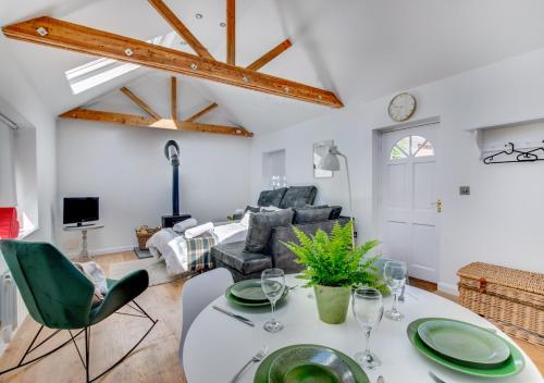 AldertonSpring House Studio的客厅配有桌子和绿色椅子