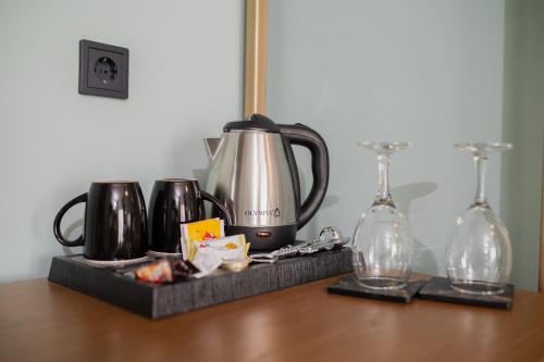 亚历山德鲁波利斯阿格洛斯酒店的茶壶和木桌上的玻璃杯