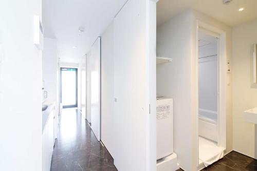 广岛bHOTEL Komachi - New Apt for 6ppl close to the PeacePark的走廊设有白色墙壁、洗衣机和烘干机