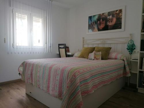 阿尔么丽亚Casa Paraiso的白色卧室,配有带条纹毯子的床