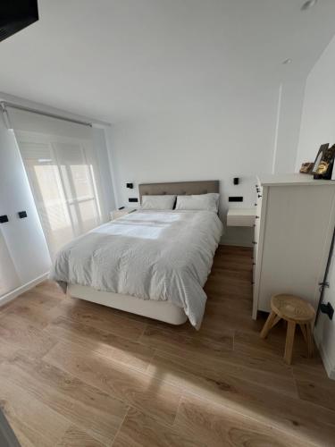 阿尔法法尔Como en casa!的一间铺有木地板的白色卧室,配有一张床