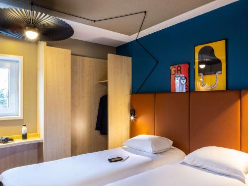 欧奈索斯博伊斯宜必思欧奈苏布瓦帕丽斯世博酒店的一间卧室设有两张床和蓝色的墙壁