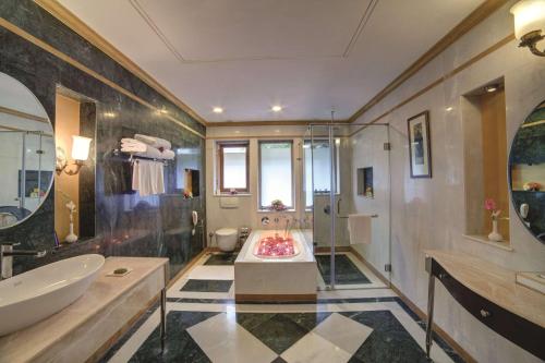 乌代浦华美达乌代布尔度假酒店的带浴缸和盥洗盆的大浴室