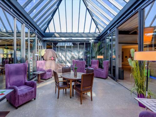 拉德菲尔德莱比锡斯达尔丝宜必思酒店的一间用餐室,配有紫色椅子和一张桌子