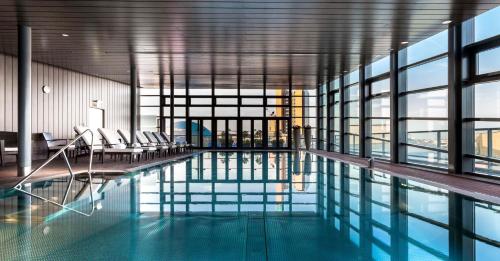 柏林柏林君悦酒店的一座带椅子和窗户的游泳池