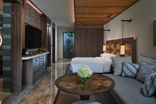 沙努尔Andaz Bali - a Concept by Hyatt的酒店客房,配有床和沙发