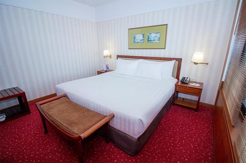 雅加达红顶会议中心酒店 的卧室配有一张白色的大床和两张桌子
