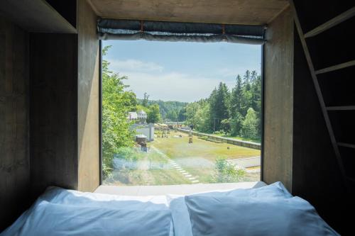 普热罗夫Hrad Kunzov Glamping & SPA & Restaurant的卧室窗户享有公园景致