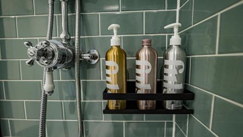 伯恩茅斯Burlington Mansions - Stunning Coastal Apartment的浴室里的架子上装着三瓶