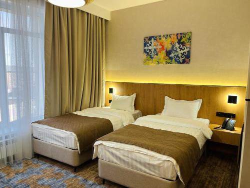 ZhezqazghanKHAN ORDASY的酒店客房设有两张床和窗户。